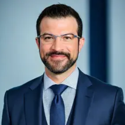 Hombre con gafas en traje azul sonriendo