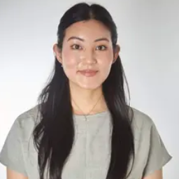 Mujer joven con cabello largo y blusa gris