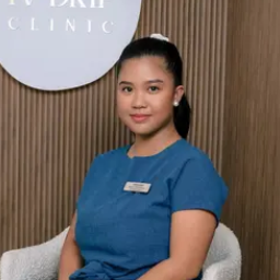Recepcionista sonriente en clínica con uniforme azul