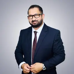 Hombre con traje azul y corbata posando