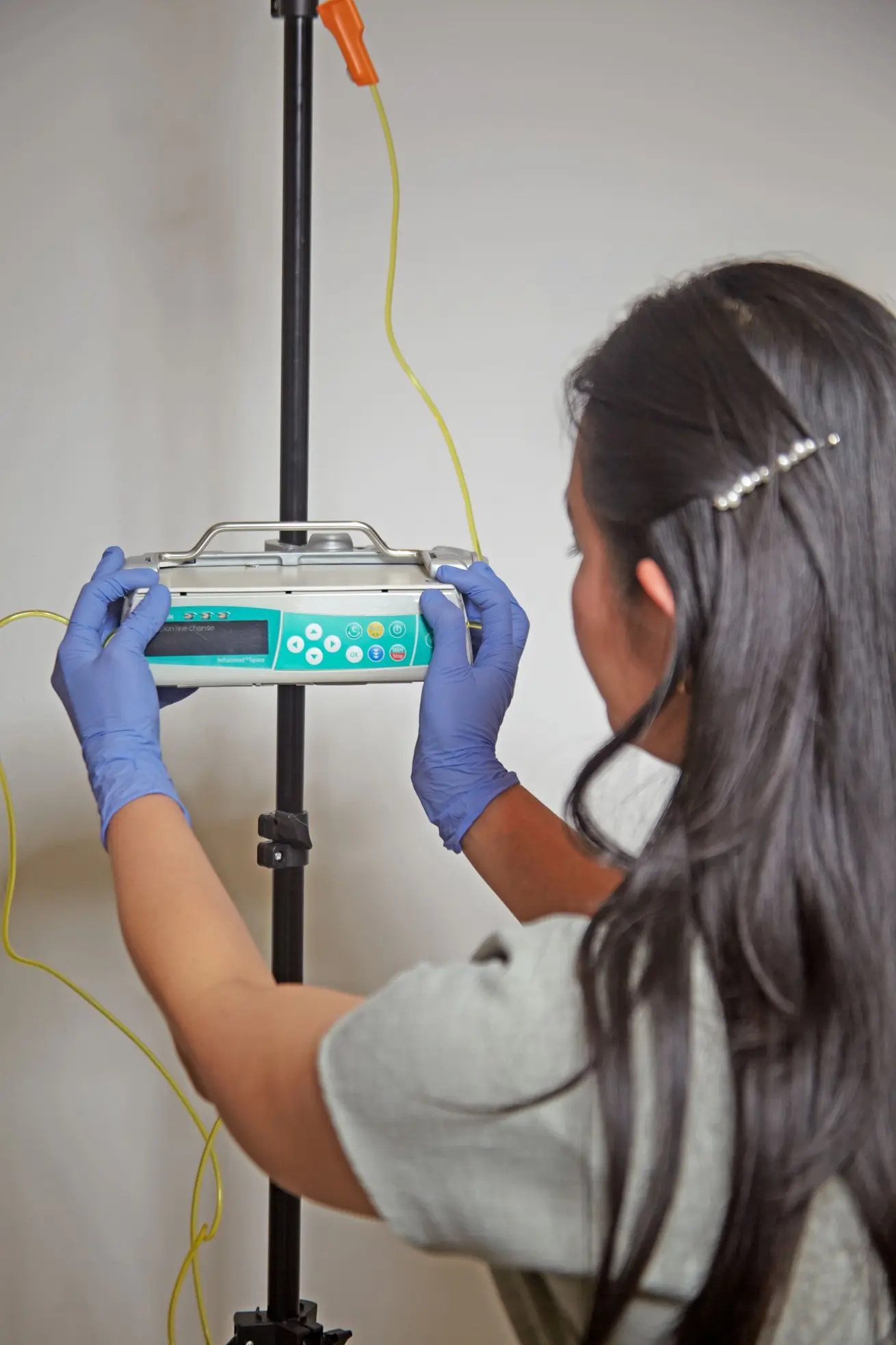 Profesional sanitaria ajustando bomba de infusión intravenosa